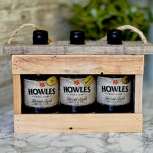 Load image into Gallery viewer, Three bottles of Howles barrel aged syrup in the wooden crate pack with plant in background
