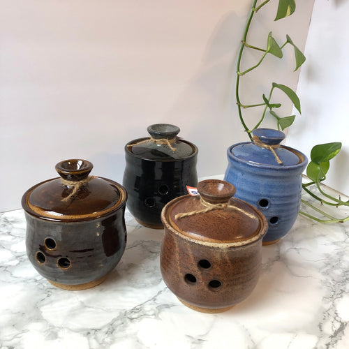 Four different colors of the ceramic garlic keepers including dark brown, black, blue and light brown