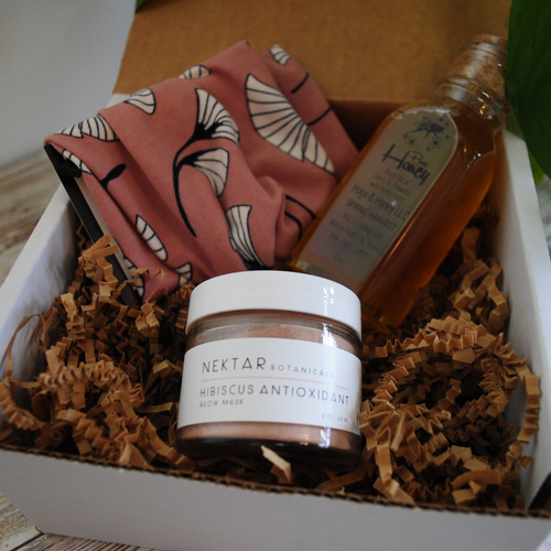 Gone Local's Glow Up Box with Nektar Botanicals glow mask, pink head band and pure honey in a glass.